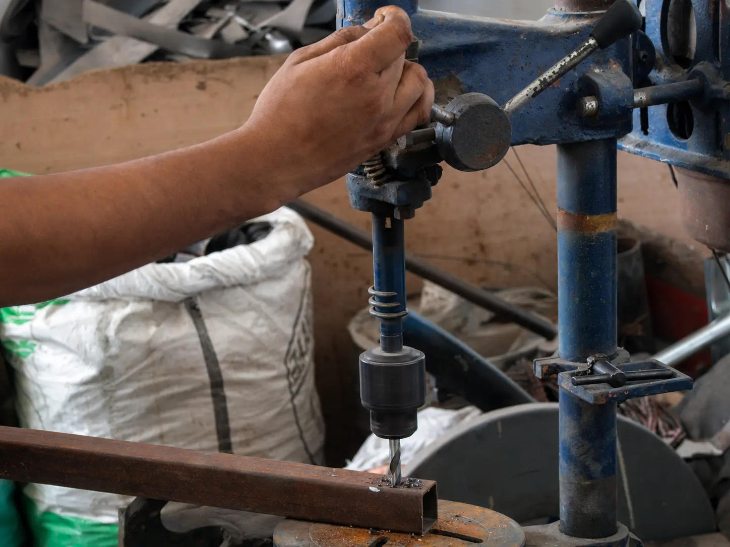 Drilling a steel furniture frame on a workshop drill press